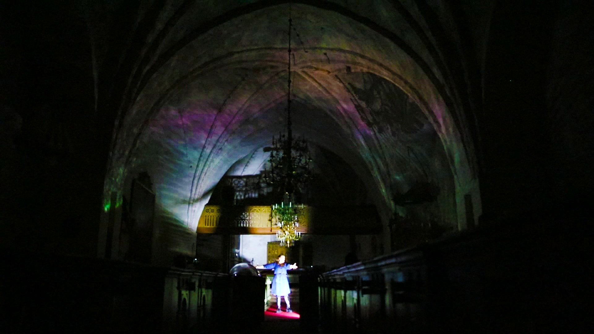 The vault washed in pastel light, the singer with open arms